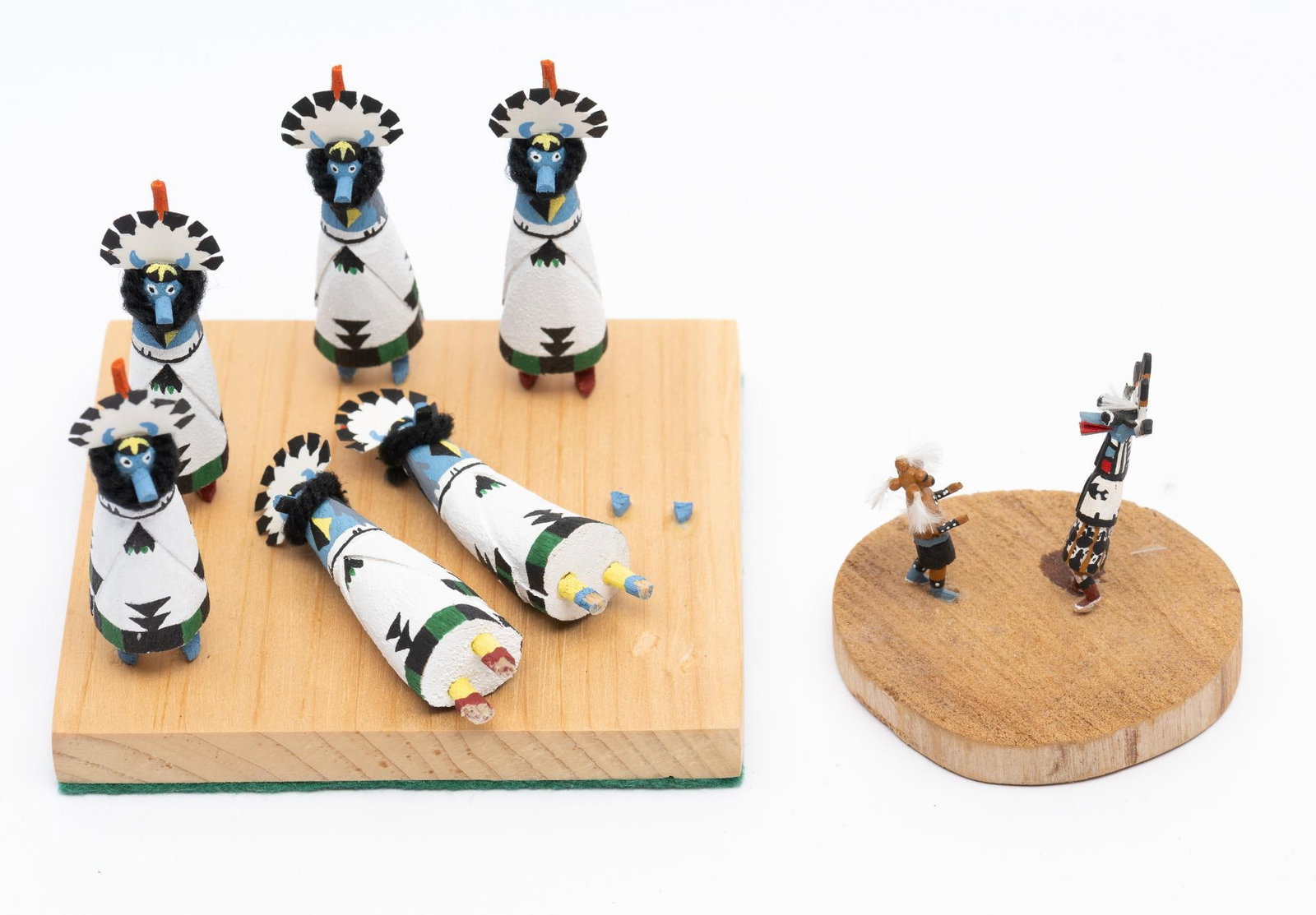 2 Miniature Katsinas or Kachinas: Two miniature groups of carved Katsinas. The first a group of blue faced dancers - Shalako. The second depicts two stylized dance figures. Measurements: 2-1/4" x 2" to 3-1/2" x 2-1/2". Condition: Two 