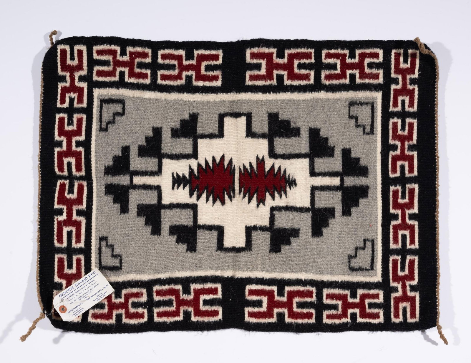 Navajo Ganado Weaving by Helen Begay: A Navajo Ganado weaving with typical red and gray colors and geometric patterns. Late 20th century. Has old Pfoutz Trading Room label attached stating the weaving is by Helen Begay. Measurements: 28-3