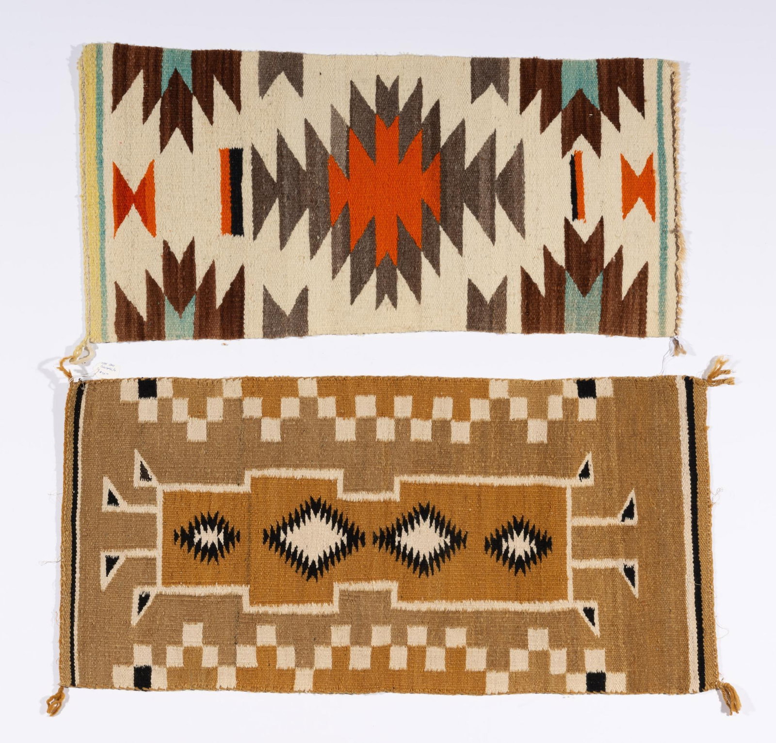 Two Navajo Weavings: Two Navajo weavings. The first a saddle blanket in bright oranges and browns. The second a small rug or table covering. Measurements: 34-1/2x16-1/2" & 37-1/2x17-3/4". Condition: Due to being in storag