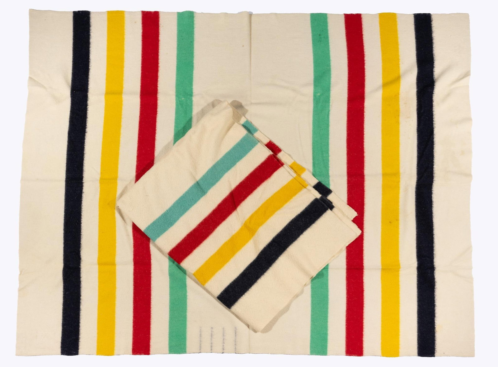 Two Hudson Bay Company Blankets: Two classic Hudson Bay Company (now "The Bay") retailed woolen blankets. The first marked as four point quality and the second as 3 1/2 point quality. Measurements: 77" x 59" and 88" x 74". Condition: