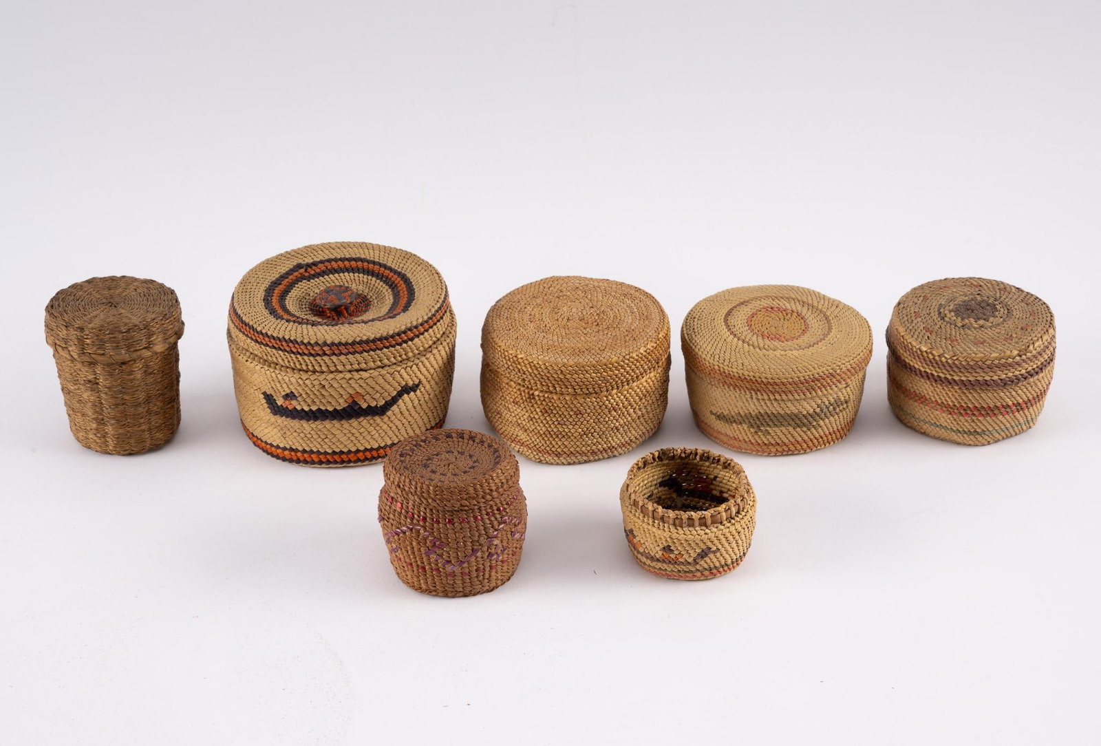 7 Small Baskets: A group of seven small tribal baskets including Quileute (Pacific Northwest), Athabaskan, and Great Lakes. Measurements: 2" to 3-1/2". Condition: Overall good.