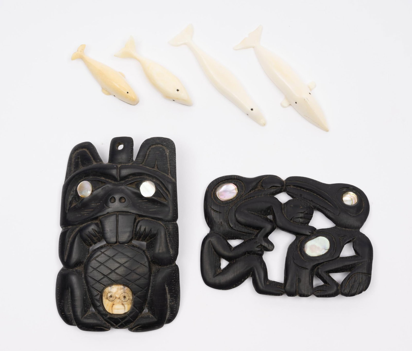 6 Carvings by Haida and Pacific Northwest Tribes: A group of six carvings including two carved argilite Haida carvings and four graduated whales. Measurements: 1-1/2 to 3-1/2". Condition: Overall good.
