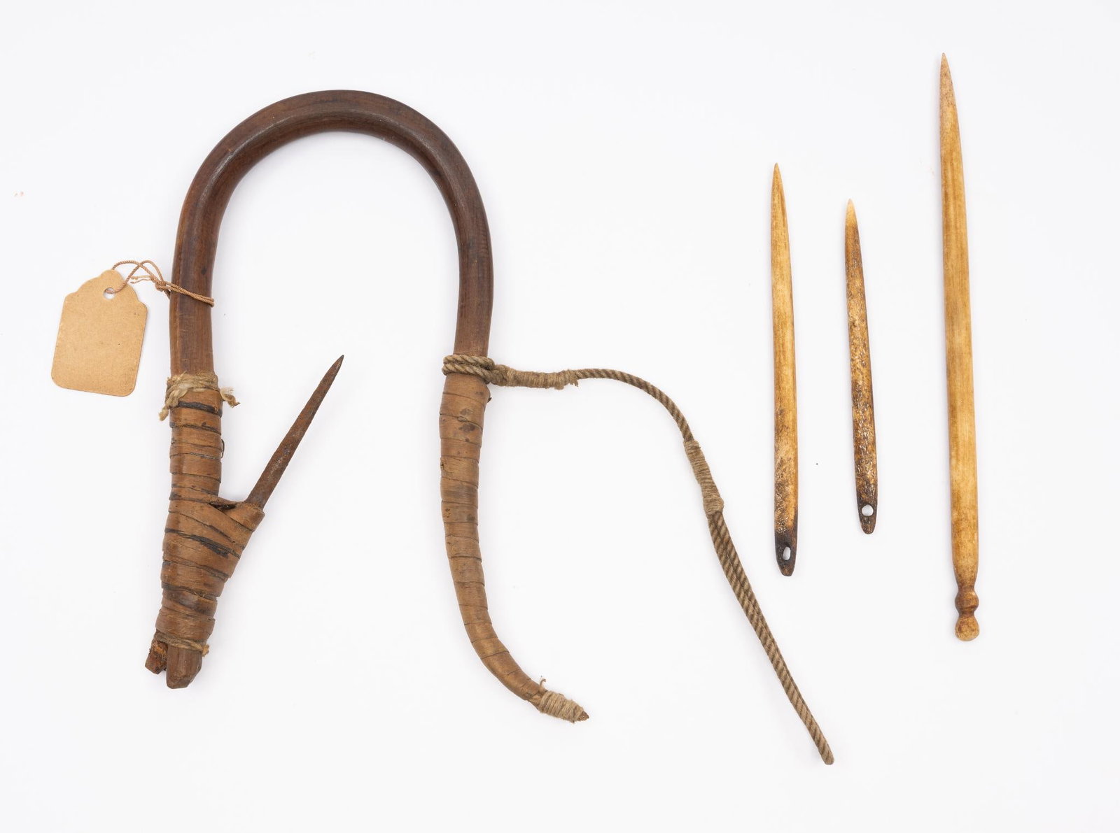 4 Northwest Tribal Items: A Haida fishing tool with old collection label and three carved bone sewing awls probably Inuit. Measurements: 3-1/2" to 6". Condition: Overall good.