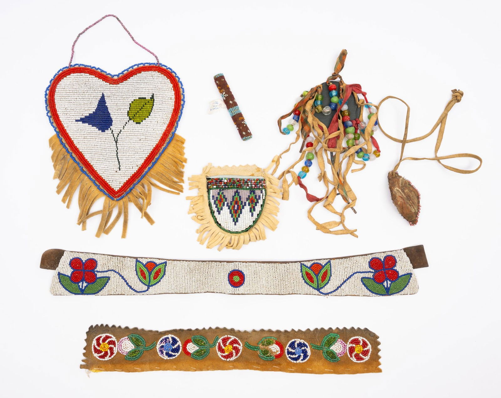 5 Plains and Athabaskan Tribal Beaded Items: A group of five beaded objects including a fine Plains (probably Iroquois) needle case, several Cree and Athabaskan panels, and an unusual very small leather fetish (perhaps 19th century). Measurement