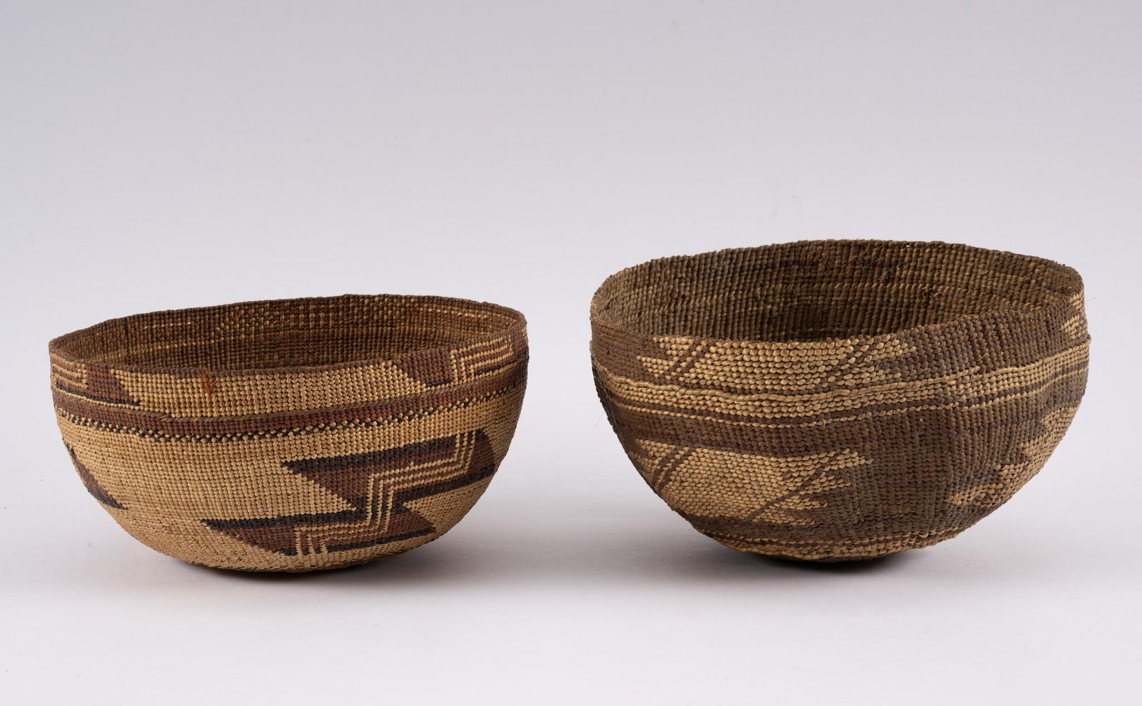 2 Woven Hupa Hats: Two woven Hupa hats probably first half of the 20th century. Measurements: 6-1/2" to 7". Condition: Some flaking of basketry.