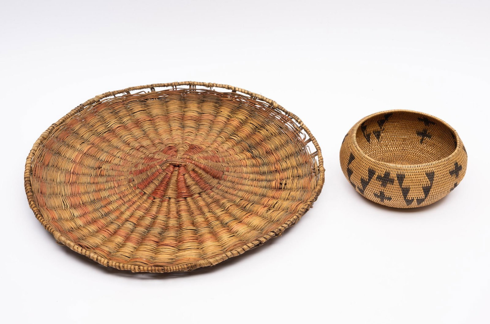 An Apache Basket and a Zuni plaque: An Apache basket with typical geometrics and made in the shape of an early 20th century art bowl. Together with a Zuni plaque with some wear and damage. Measurements: 6" to 17". Condition: Overall goo