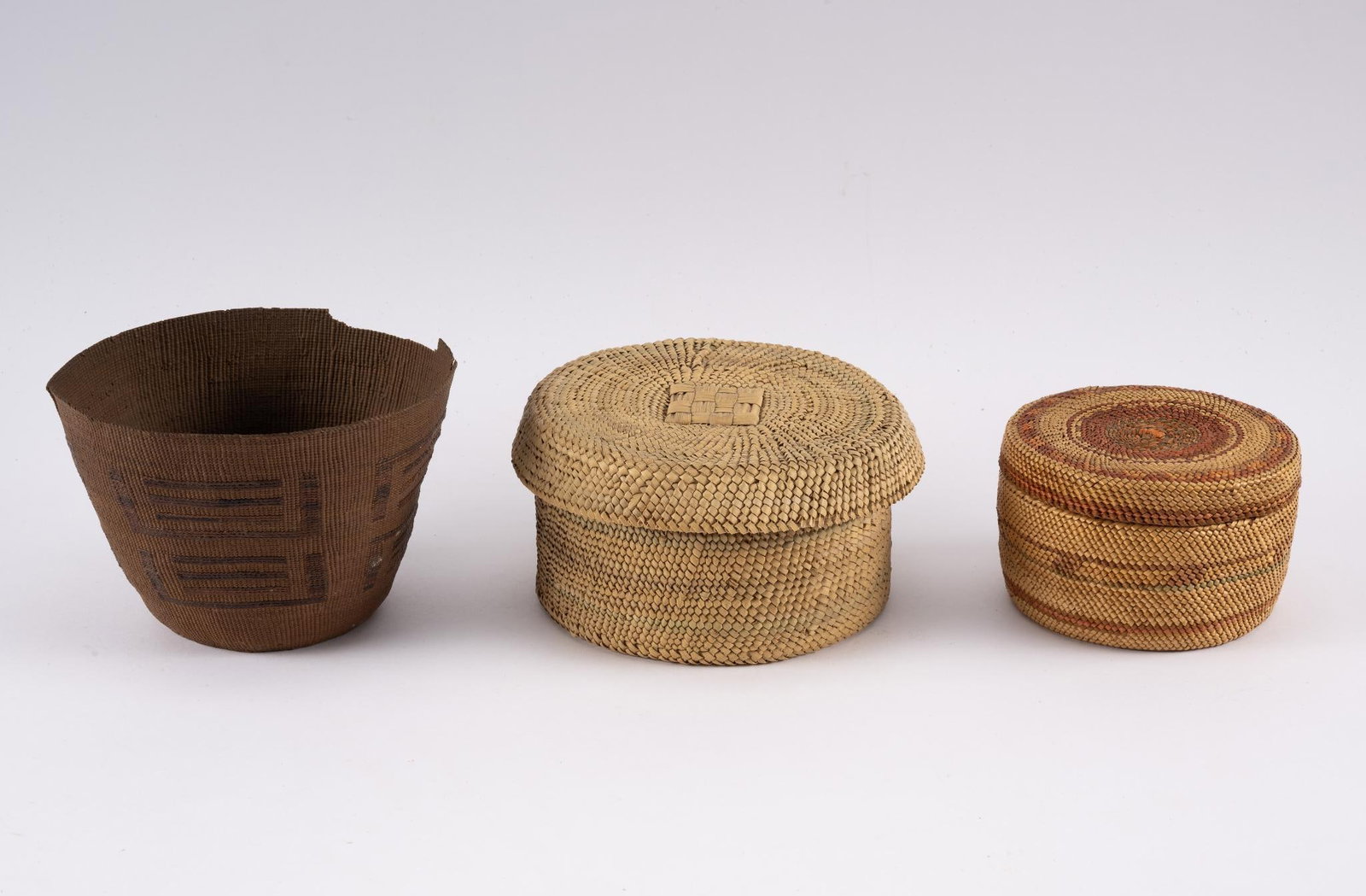 3 Tribal Baskets: Three tribal baskets including a Pacific Northwest covered container along with two other baskets. Measurements: 4" to 6" diameter. Condition: Damage to edge, but overall good.