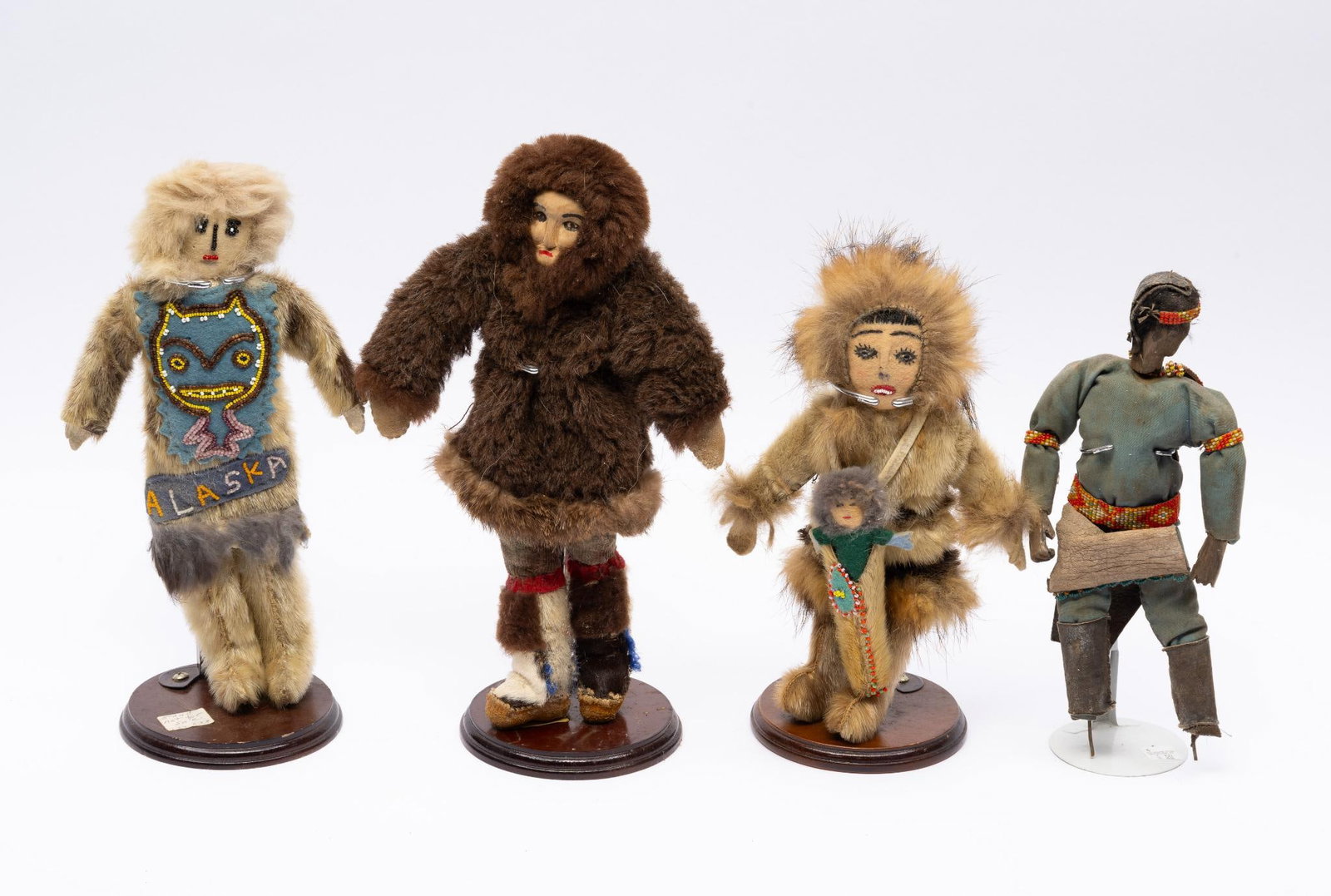 4 Tribal Dolls--Arctic and Southern Plains: Four trade dolls, 20th century. Three depict and were made by Arctic tribes and the fourth southern plains possibly Oklahoma. Measurements: 10 to 13". Condition: Overall damage normal for age.