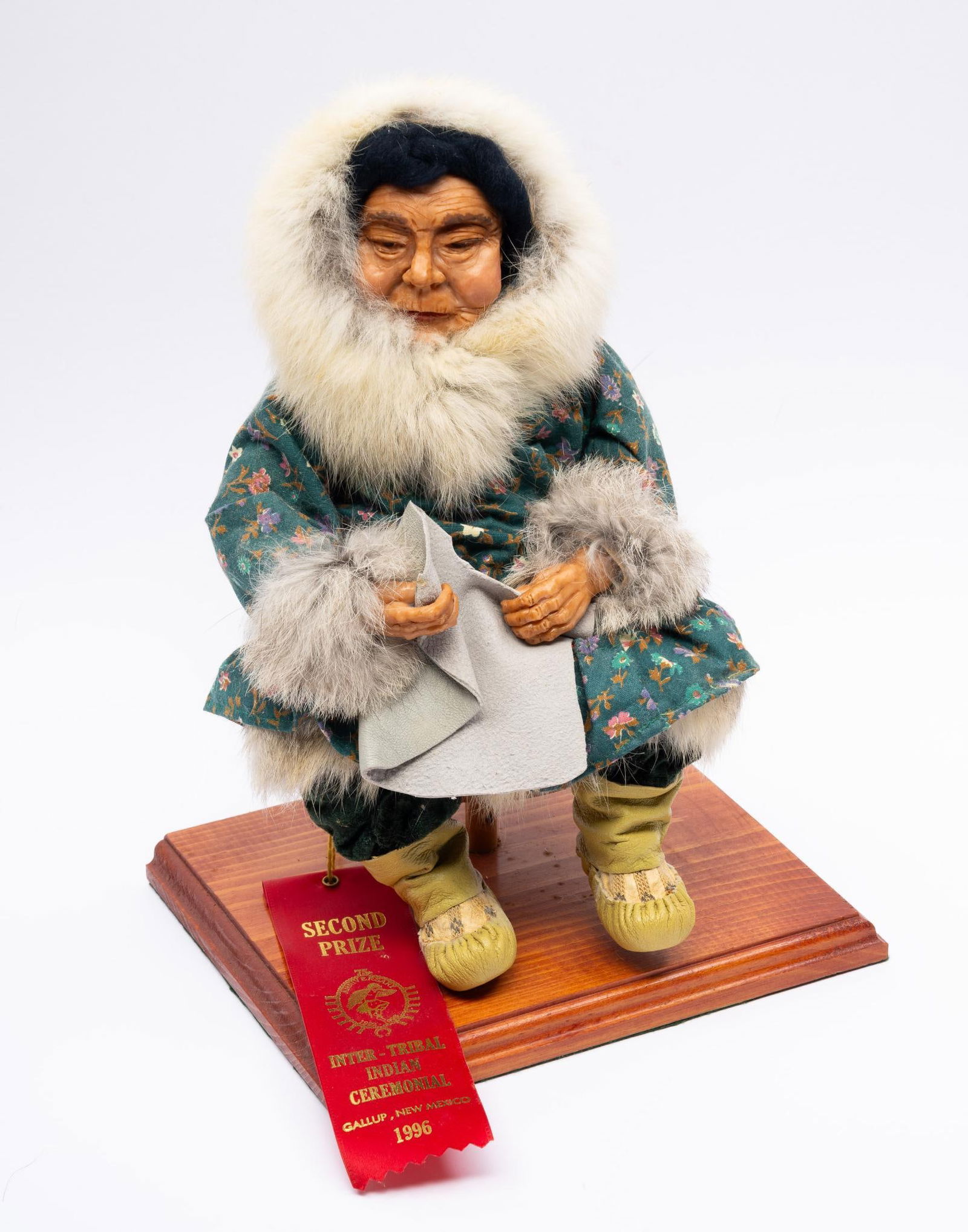 Seated Eskimo Woman Doll: Seated "Eskimo Woman" Doll. Made from polymer clay, cloth, and leather. Identified maker: C. LaFortune. With prize ribbon for Inter-tribal Indian Ceremonial Award 2nd Place 1996 Measurement: 12-1/2" t