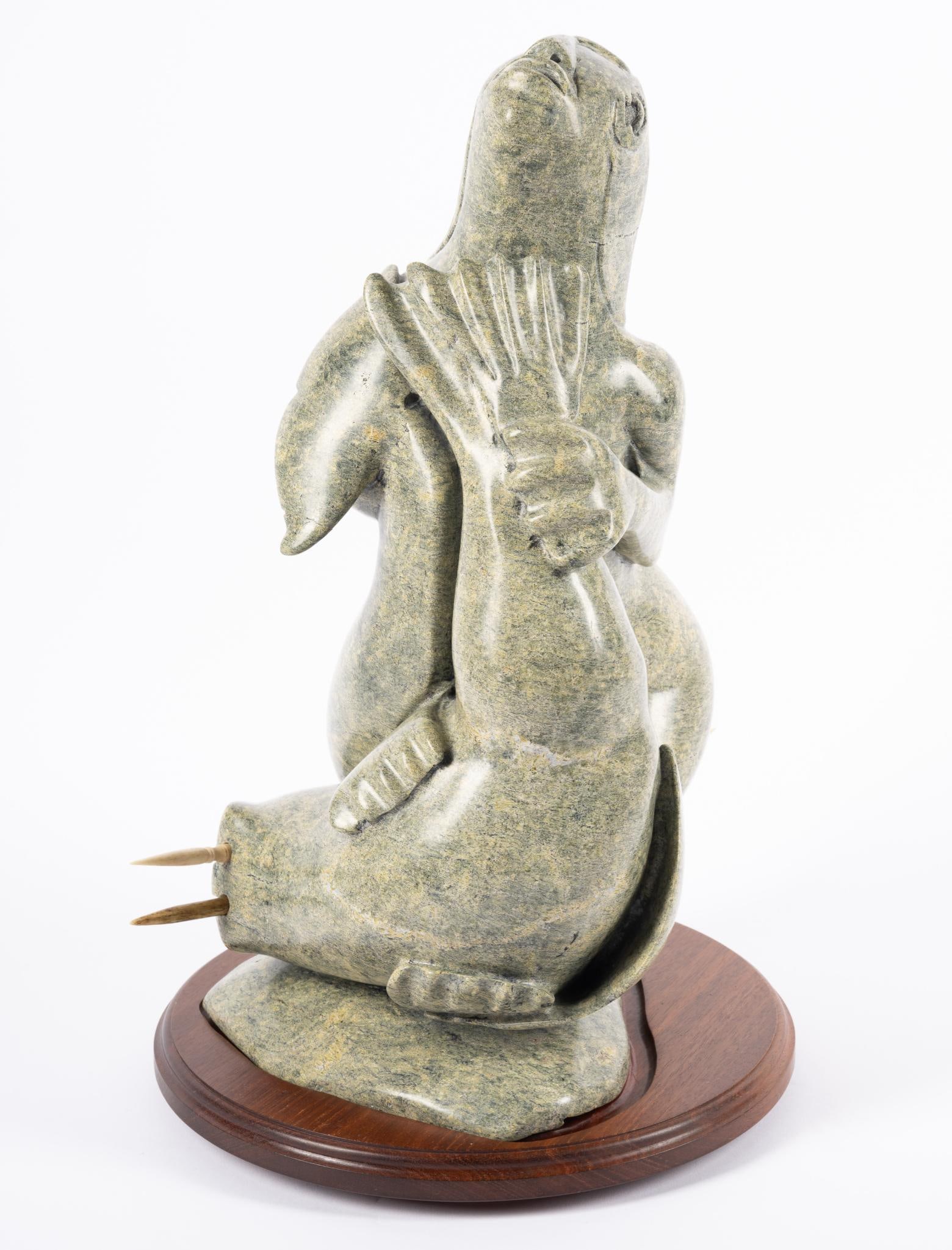Stone Carving by Inuit Kellypalik Etidloie: NOT ELIGIBLE FOR IN-HOUSE SHIPPING Other spellings Kelly, Kellipalik, Etidlooie. Hunter with walrus and narwhal. Repair to the narwhal tail and one walrus tusk apparently not matching. Height 16 1/2"