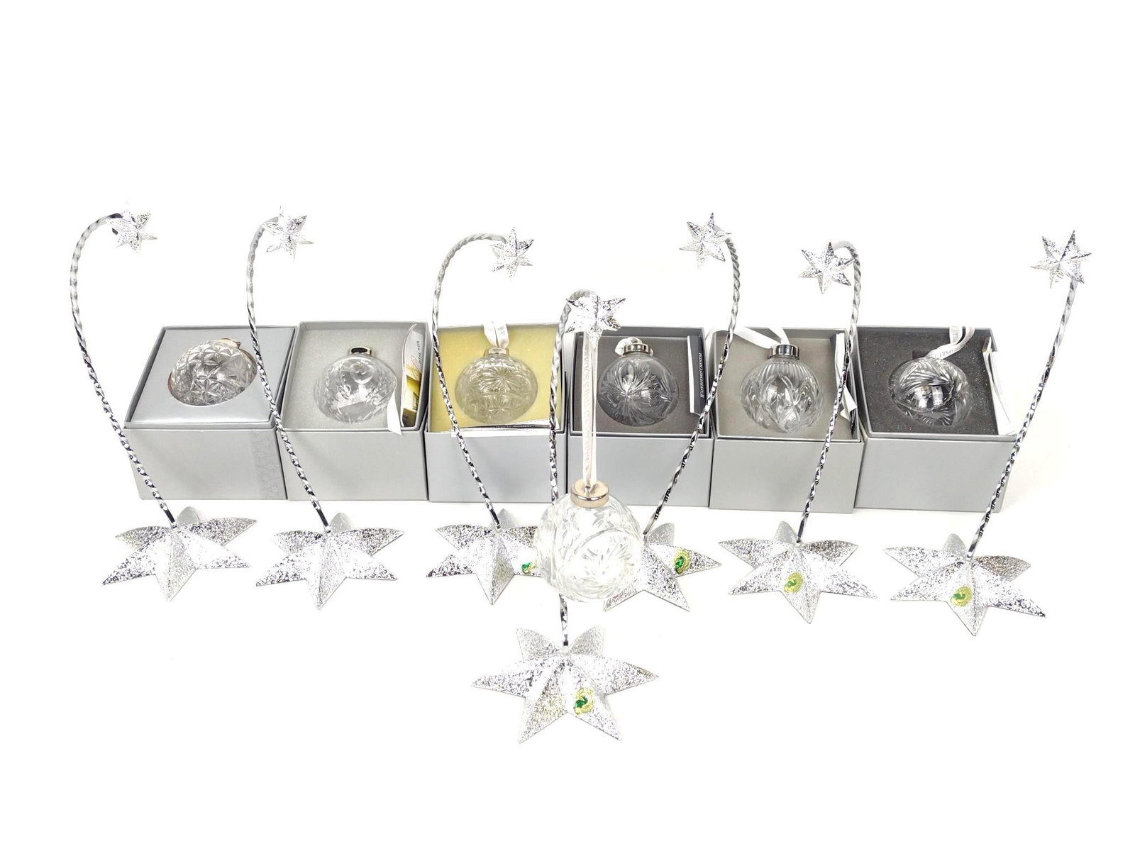 7 Waterford Christmas Ornaments & 7 Ornament Stand: Includes 7 Waterford ornaments in original boxes and 7 Waterford star base ornament stands. Stand overall measures 8" wide x 11" high. Ornaments include Times Square Ball Ornament; Hope for Abundance;