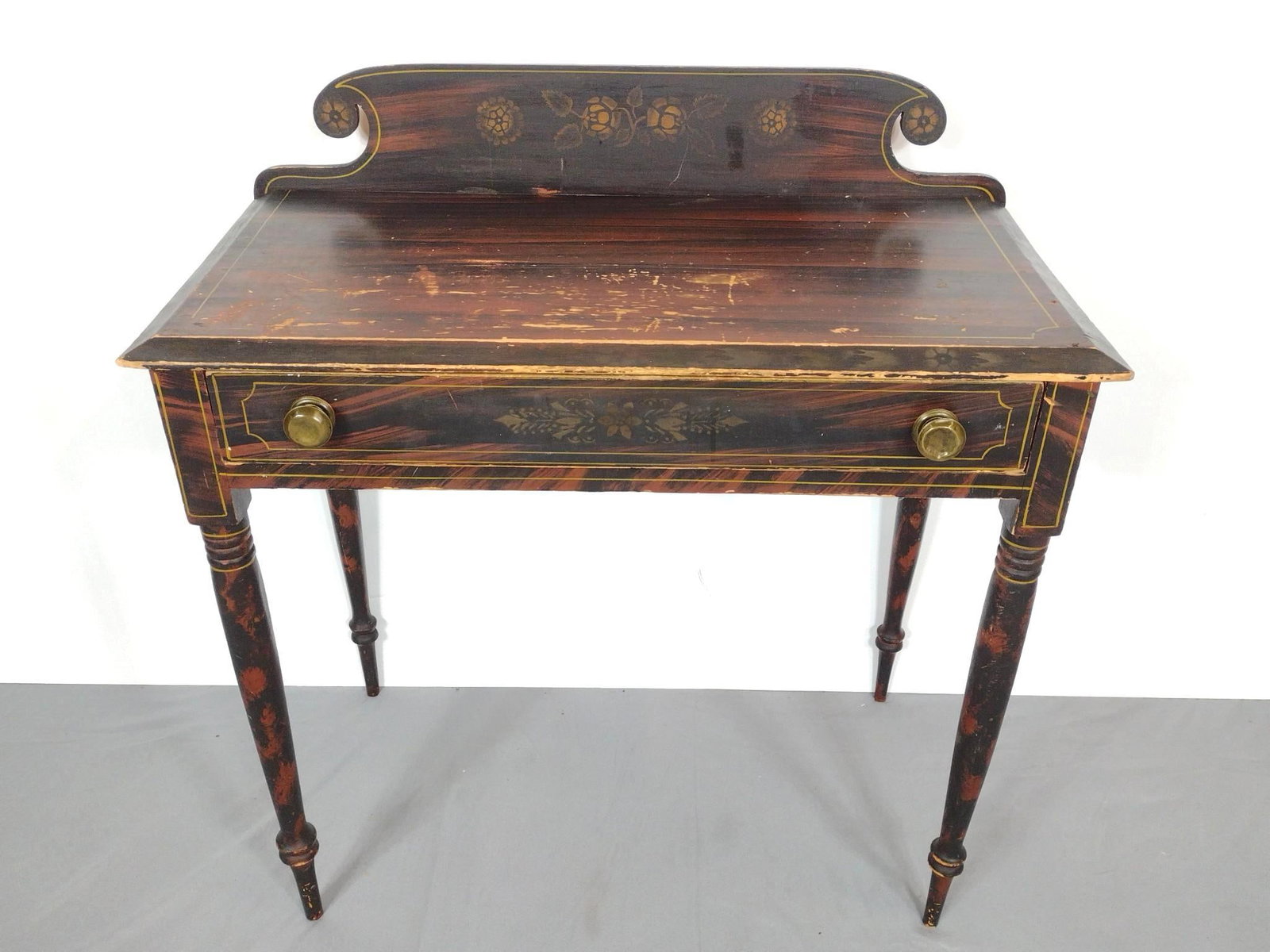 19th Century Writing Desk: NOT ELIGIBLE FOR IN-HOUSE SHIPPING. 32" wide X 16" deep X 33" high. Grain painted with line inlay. Brass pulls. Wear to top. Has some scratches and finish loss.