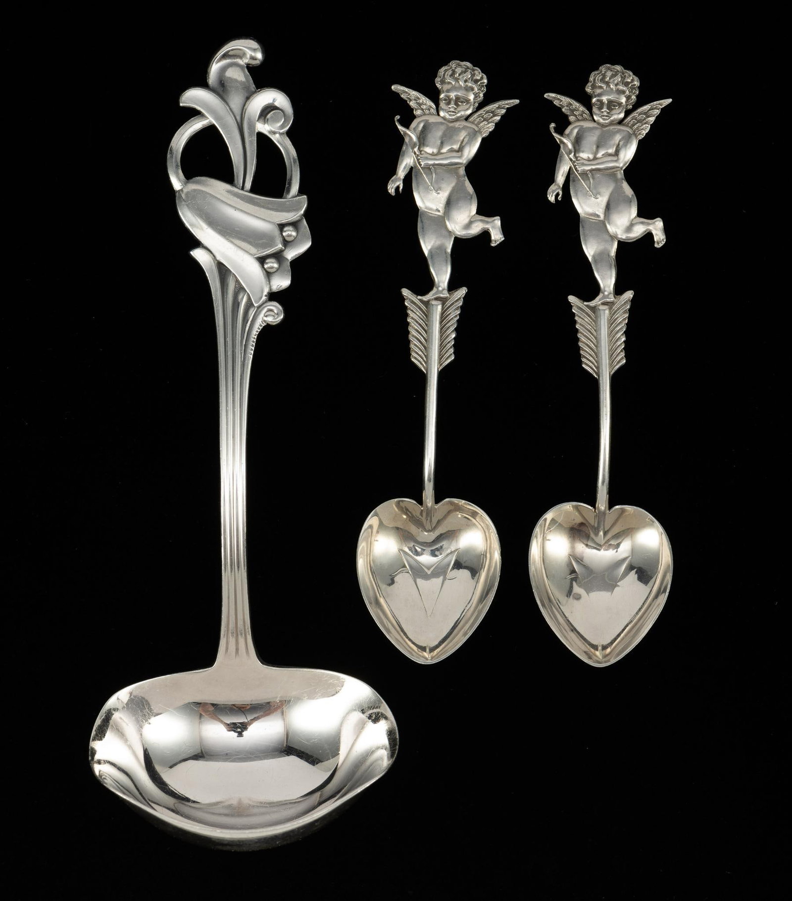 3 Sterling Silver Spoons: Includes 2 cupid spoons marked W.C. Finsk; one Norwegian sterling spoon. 3-7/8" to 5" long. 1.53 ozt total.