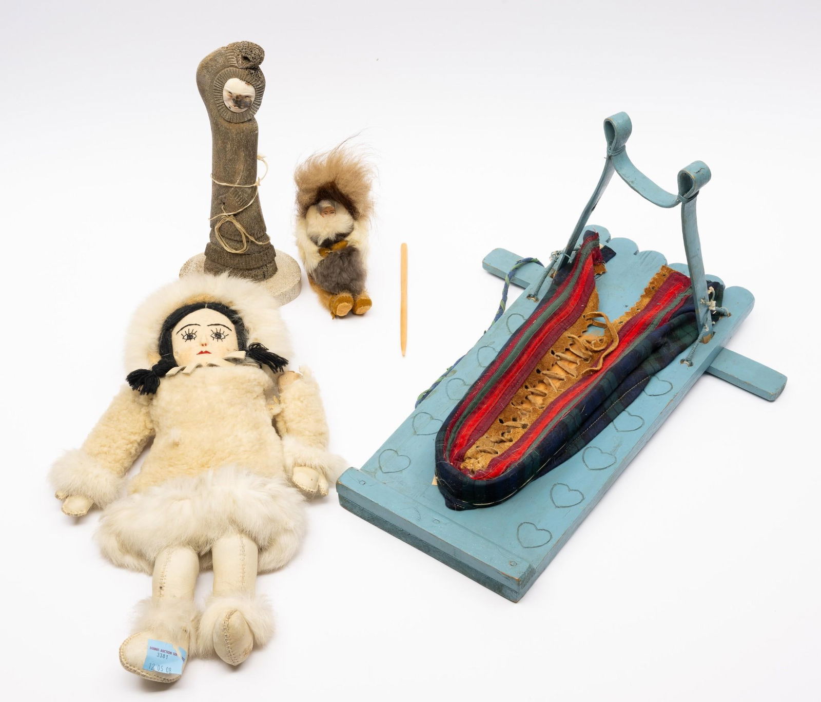 Two Dolls, a Toy Cradleboard and a Carving: Two Arctic dolls, a carved bone and baleen figurine, and a toy cradle board. 25-1/2" to 17" tall. One doll arms are loose & cradle board has some loose pieces, but overall fine.