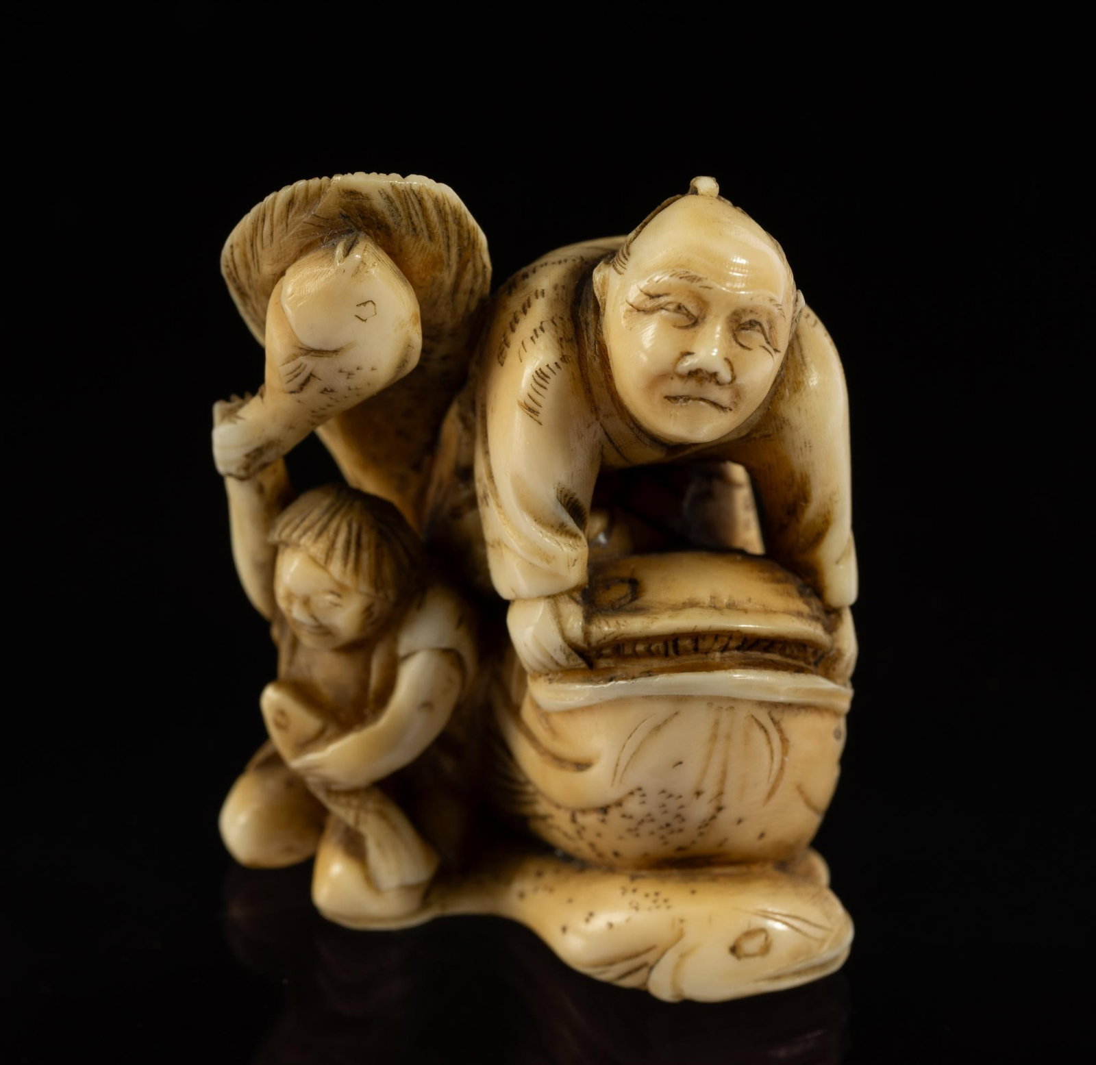 Carved Bone Katabori Netsuke: DESCRIPTION: 19th century. Two men fishing. One sitting on giant fish. Second man holding two fish. Netsuke are miniature sculptures, originating in 17th century Japan. It was initially a simply carve
