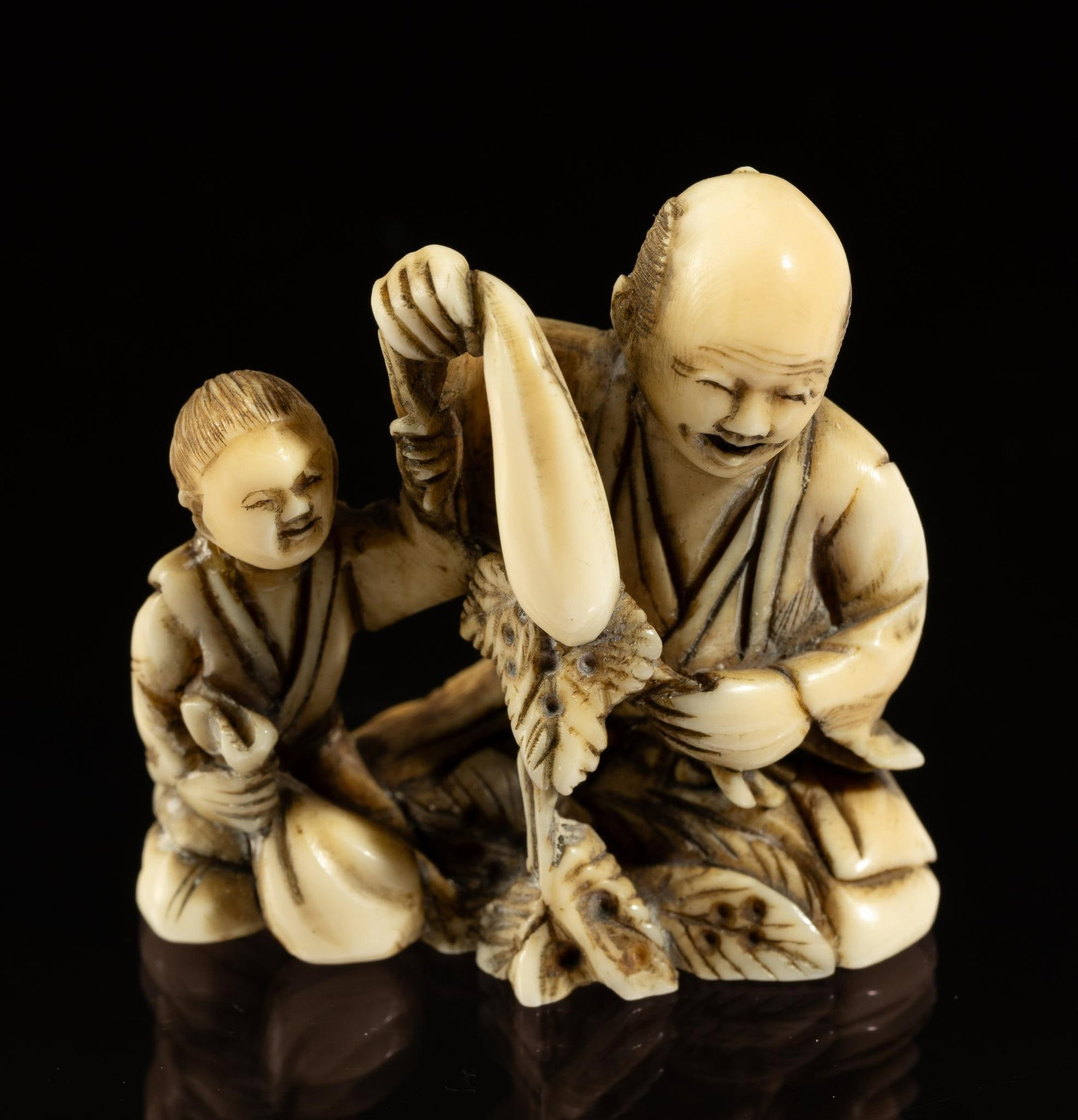 Carved Bone Katabori Netsuke: DESCRIPTION: 19th century Meiji Japanese Katabori Netsuke. Two figures, one older and one younger. Both figures sitting holding sacks. Netsuke are miniature sculptures, originating in 17th century Jap