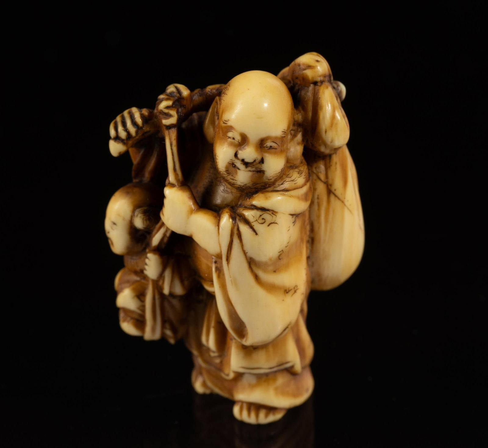Carved Bone Katabori Netsuke: DESCRIPTION: 19th century Meiji Japanese Katabori Netsuke. Budai figure carrying a sack and another figure. Netsuke are miniature sculptures, originating in 17th century Japan. It was initially a simp