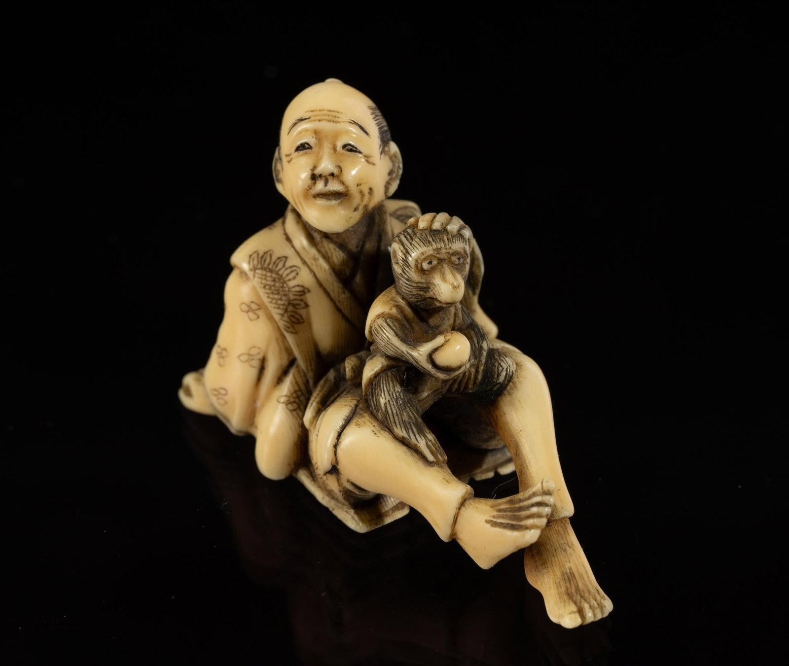 Carved Bone Katabori Netsuke: DESCRIPTION: 19th century Meiji Japanese Katabori Netsuke. Man sitting with a monkey on his lap. Netsuke are miniature sculptures, originating in 17th century Japan. It was initially a simply carved b