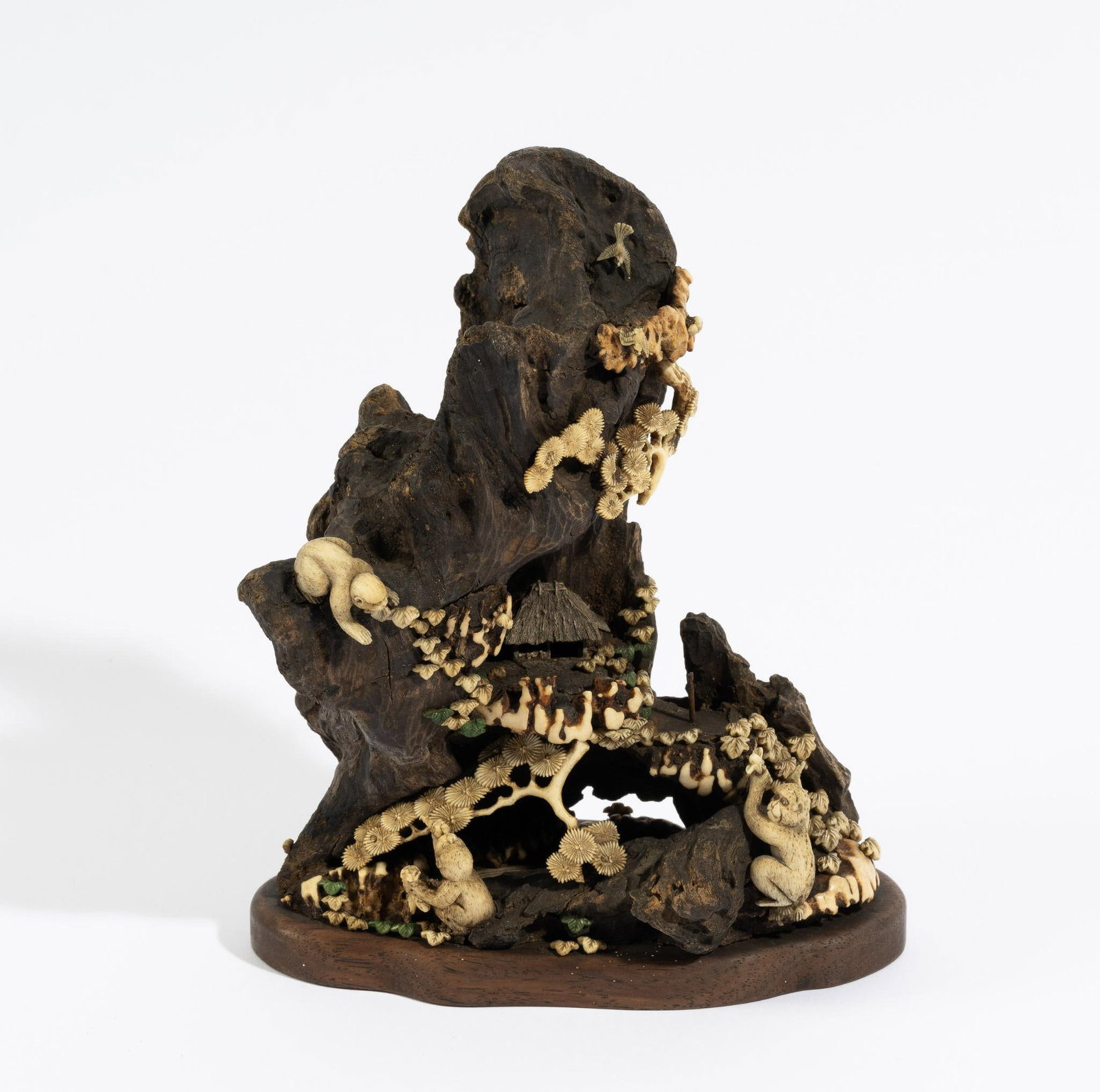 Wood Bone Carving: DESCRIPTION: Carved wood with carved bone embellishments in the shape of monkeys, flowers, and mushrooms. Mounted to a wood base. MEASUREMENT: 5-1/4" wide x 3" deep x 6-3/8" high. CONDITION: Piece mis