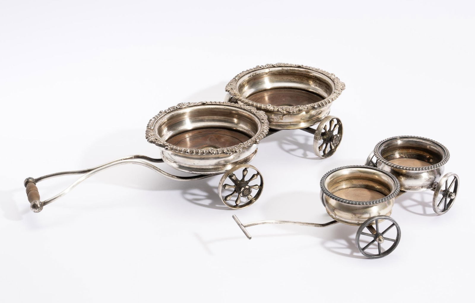 2 English Silverplate Wine or Condiment Trolleys: DESCRIPTION: Includes larger wood lined coasters for larger decanters or condiment dishes, English early 1900s; and second smaller trolley stamped Victoria (by Taunton Silversmiths, Taunton, MA) later