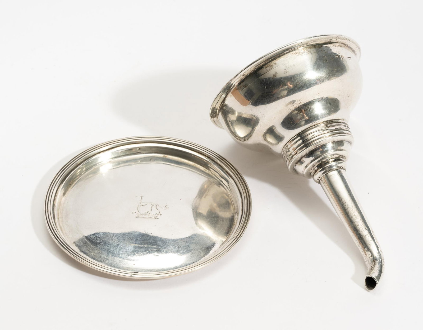 Antique English Sterling Silver Wine Funnel and Dish: DESCRIPTION: Both pieces stamped and both with coat of arms/hallmark consisting of a saluki or similar greyhound perched atop a crown. The funnel is a two piece example. Possibly Richard Britton, Lond