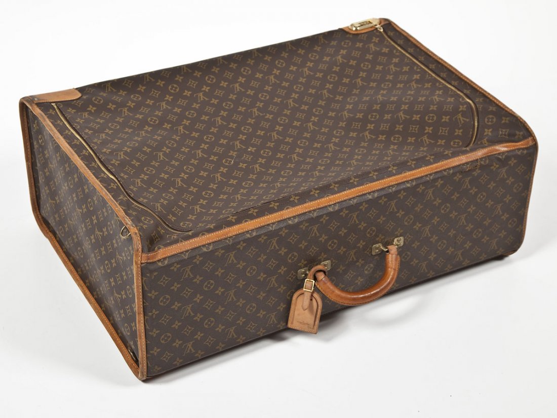 Louis Vuitton Large Softside Suitcase: DESCRIPTION: Louis Vuitton large softside suitcase with brass hardware including a combination lock at the start of the zipper. With a hard top and leather handle and interior straps. With luggage tag