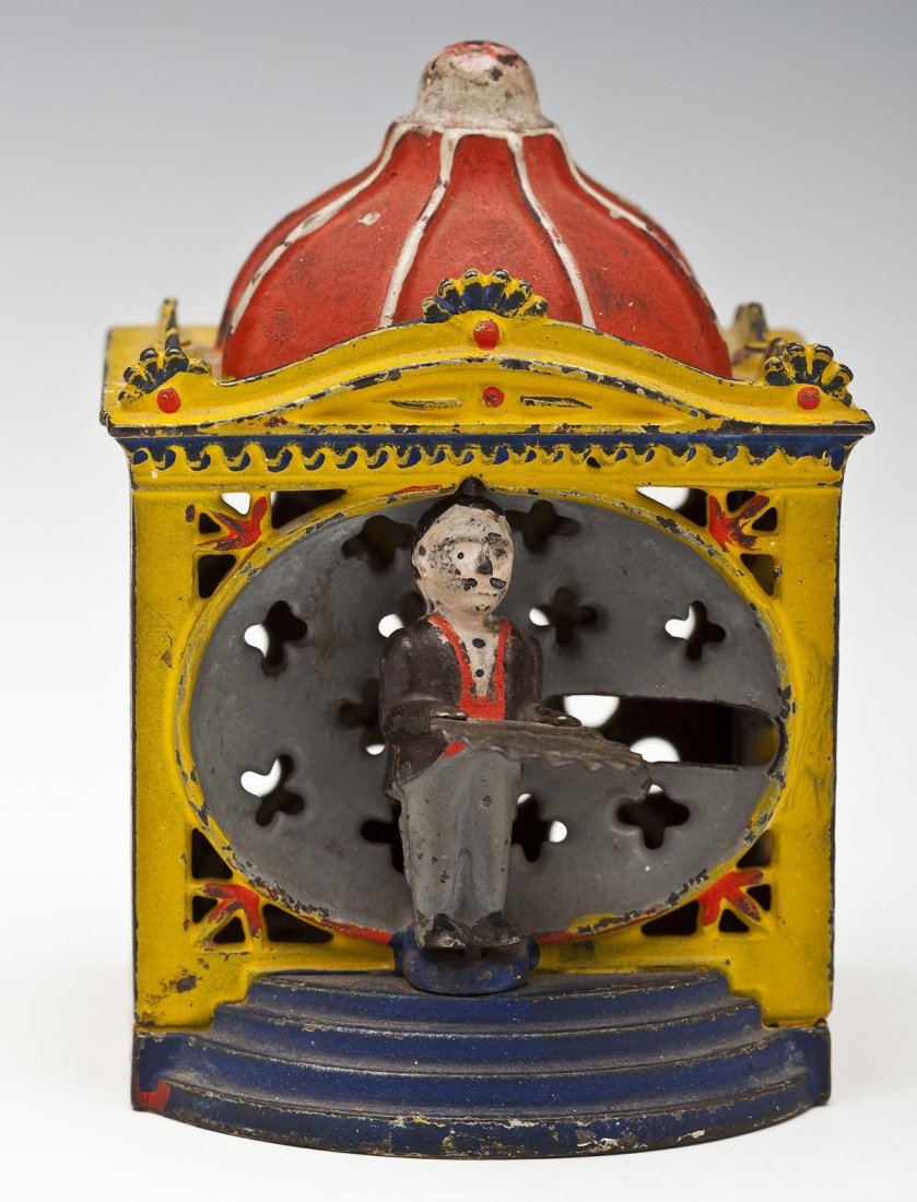 19th C Hall's Liliput Mechanical Bank: DESCRIPTION: Hall's Liliput mechanical bank depicting a man with a tray just outside of a yellow building with a red domed top and blue steps. Manufactured by J. & E. Stevens and patented by John D. H