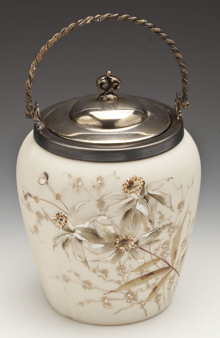 Victorian White Enameled Satin Glass Cracker Jar: DESCRIPTION: Victorian white enameled satin glass cracker jar, possibly C.F. Monroe. Handpainted with enameled mauve colored flowers. With metal lid and handle. MEASUREMENTS: 9-1/2" high with handle. 