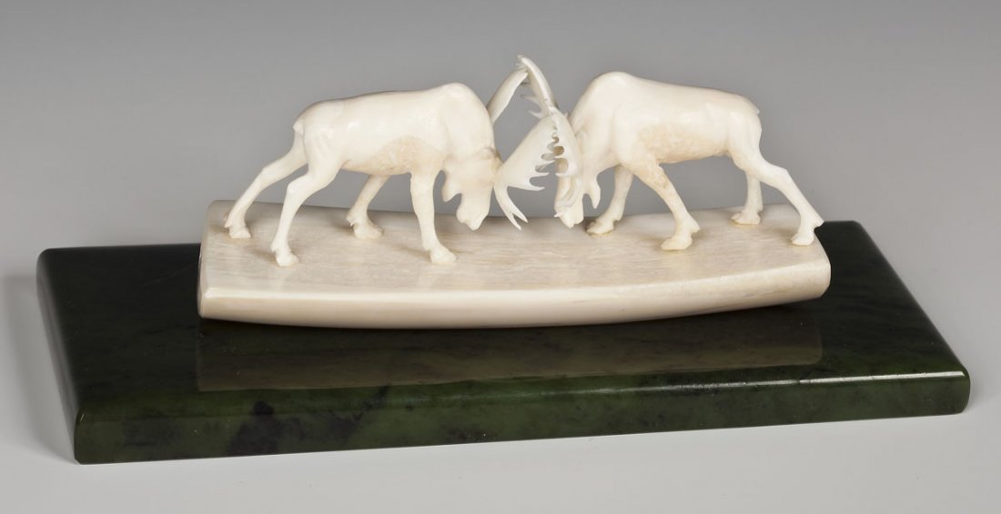 Alaskan Ivory Moose Carving: DESCRIPTION: Alaskan ivory moose carving on a green marble base. Circa 1989. Depicts two moose fighting. Signed and dated "8.89," on the side. MEASUREMENTS: 2" x 5". Base 7" x 3-1/8". CONDITION: No de