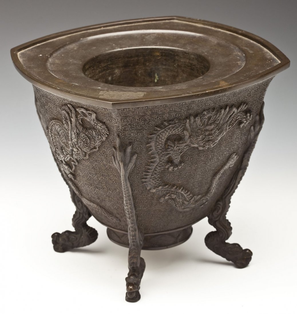 Japanese Bunsei Bronze Usubata Flower Vase: DESCRIPTION: Japanese bronze usubata flower vase. Etched and carved geometric design with dragons on each of the four sides. With four dragon feet. Seal on the bottom marked "Dai Nippon Bunsei Nen Sei