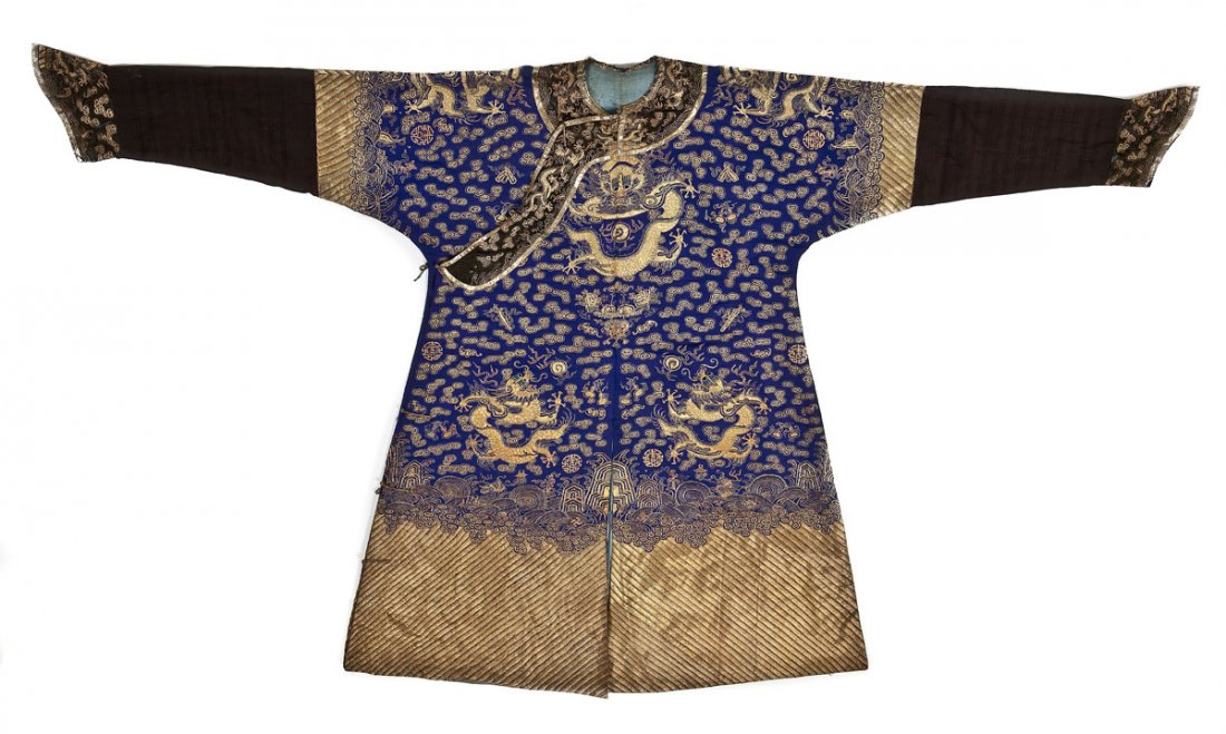 Chinese Qing Dynasty Embroidered Dragon Robe: DESCRIPTION: Chinese blue dragon robe couched with metallic gold threads of dragons amid clouds and auspicious symbols with a lishui border and sea wave design on the bottom hem. With a light blue sil