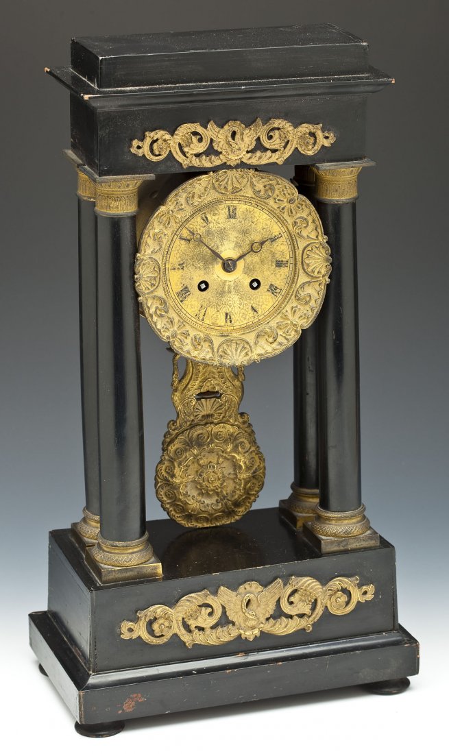 Antique French Portico Mantle Clock: DESCRIPTION: Antique French portico mantle clock with a rectangular molded cornice with gilt mounts set on four columns with gilt capitols and base enclosing a circular clock face with Roman numerals.