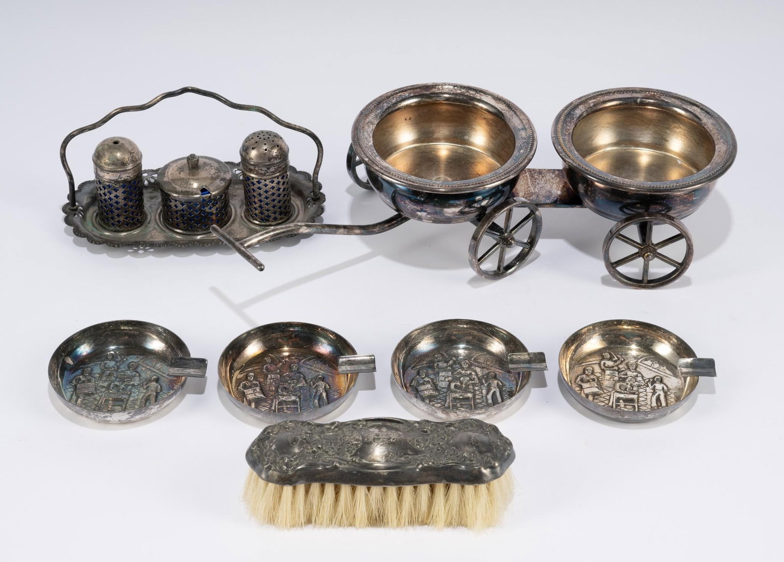 7 Pcs Silverplate: Includes salt/pepper/mustard set (missing spoon), brush, 4 ashtrays, and wine trolley. Trolley with handle 13" long.
