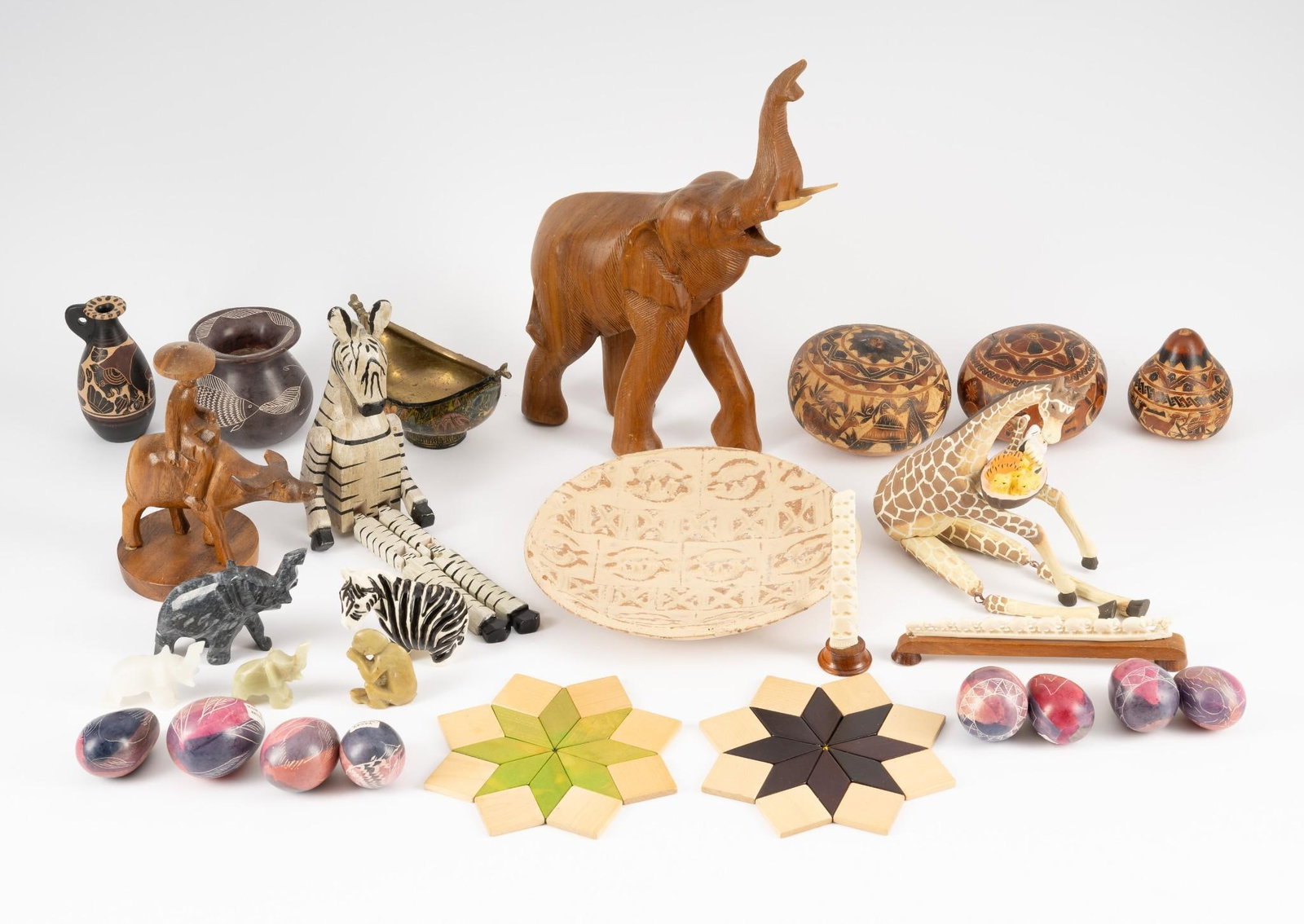 28 Ethnographic Articles incl Carvings: Includes wood carvings, pottery eggs marked Made in Kenya, carved gourds, misc. pottery, bone carvings, and hardstone animal figurines. 1" to 13-1/4" high.