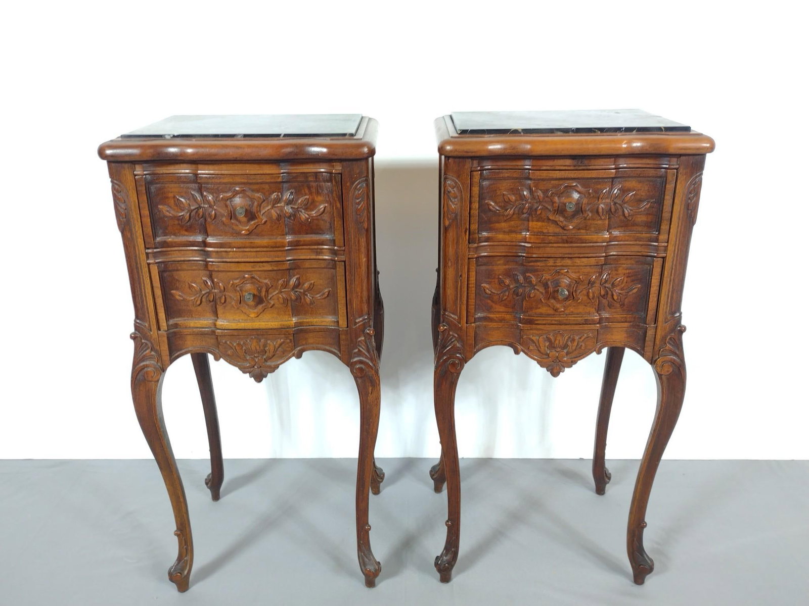 Pair Of Marble Top Carved Night Stands: NOT ELIGIBLE FOR IN-HOUSE SHIPPING. Each 14" wide X 11-1/4" deep X 29-3/4" high. One marble top is split in two spots.