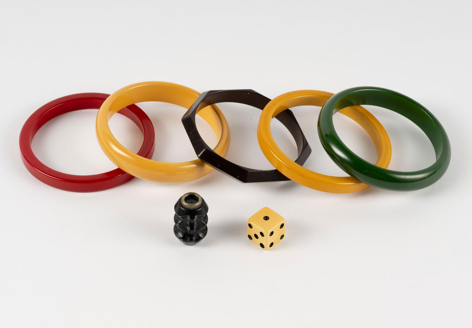 7 Pcs Bakelite: Includes five bangle bracelets, each 2-1/2" interior. One pendant and one single die.