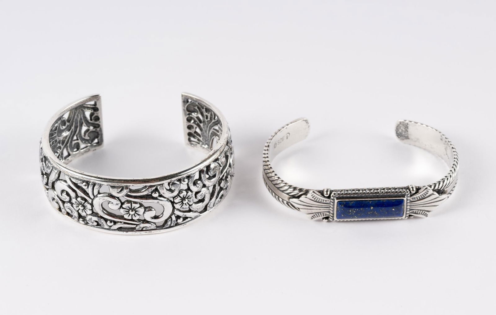 2 Relios by Carolyn Pollack Cuff Bracelets: Includes floral sterling filigree, interior 1-3/4" x 2-1/4", top 1" wide. Sterling with lapis, interior 1-1/2" x 2-1/2", top 3/8" wide. Both marked.