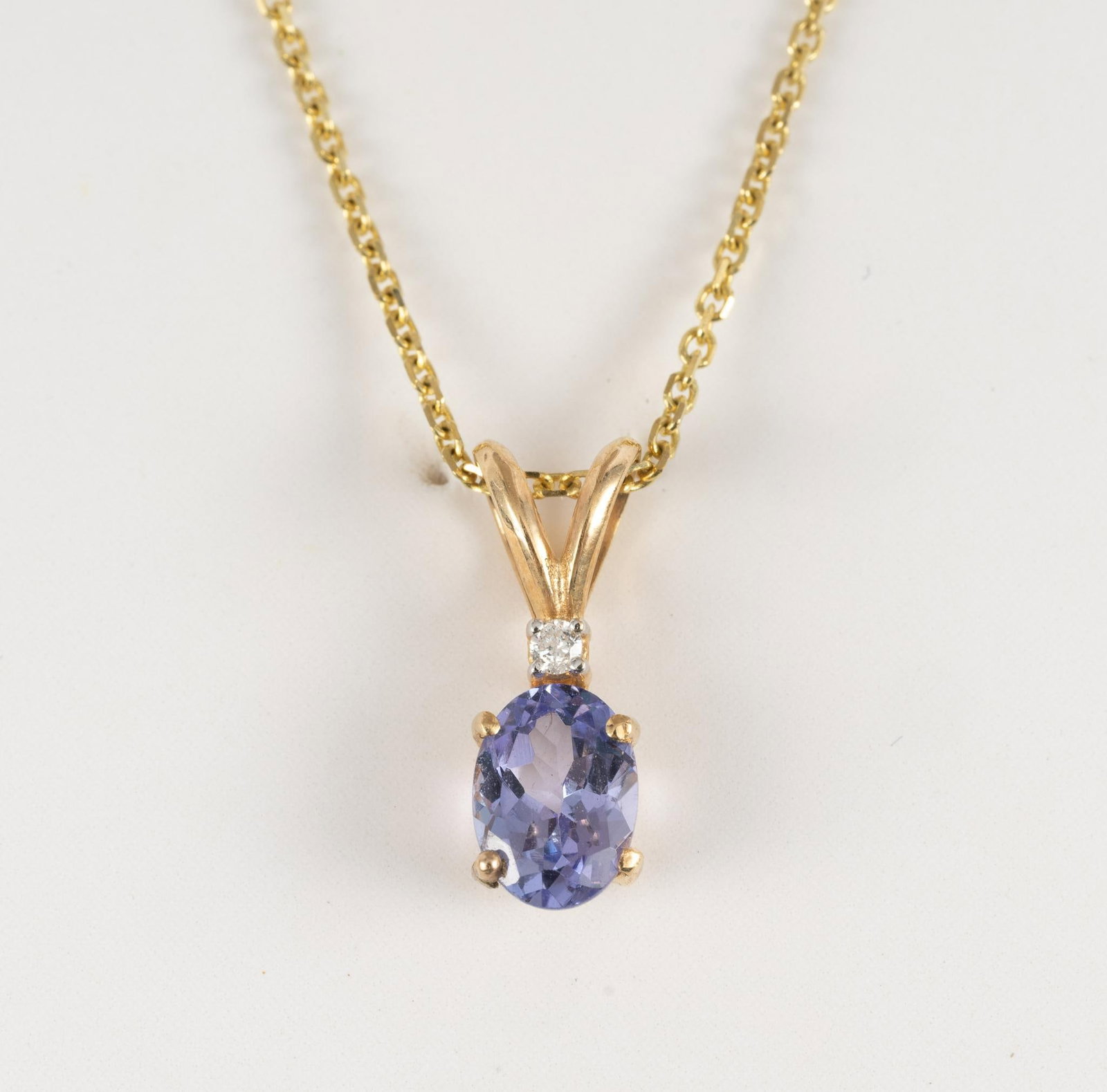 14K Gold Tanzanite and Diamond Pendant Necklace: Tanzanite pendant with diamond accent on a delicate 18" cable chain. The chain weighs 1.5 grams and the pendant weighs 0.7 grams.