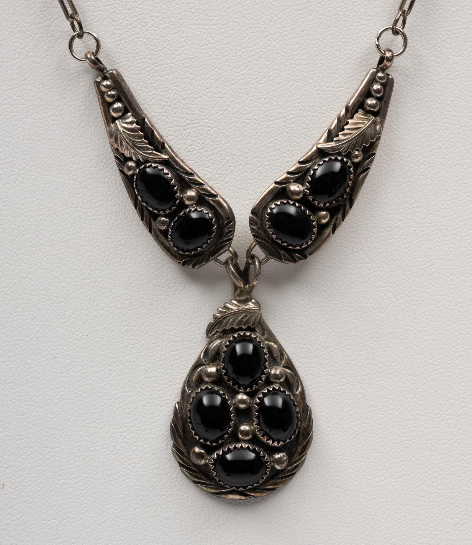 A. Martinez Navajo Sterling Silver & Onyx Necklace: Alfred Martinez onyx necklace, stamped sterling and A M. Center pendant 1 1/2" length and with pendant pair above 1 3/4" each. 22" chain including the pendant pair inline on the chain.