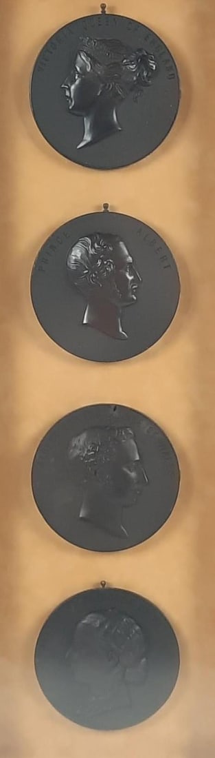 4 Royal Commemorative Medallions / Plaques in Shadow Box Frame: NOT ELIGIBLE FOR IN-HOUSE SHIPPING. Medallions / plaques each: 4-1/2" diameter. Overall with frame: 25" high x 9" wide. Glass is foggy. Some losses to plaques consistent with age and use.