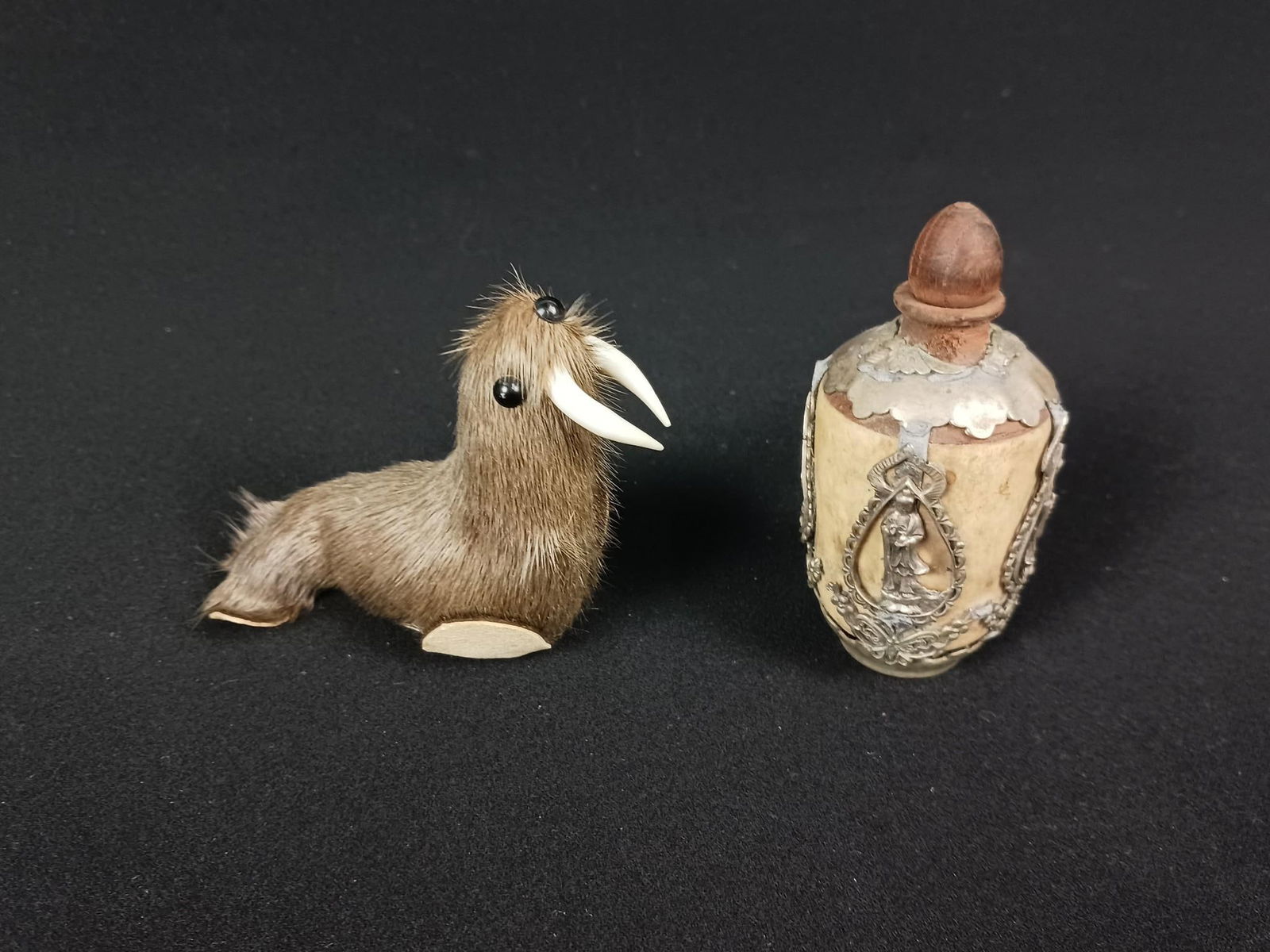 Bone Snuff Bottle and Walrus / Sea Lion Figure: Snuff bottle with metal accents. Walrus / Sea Lion made of leather and hair. Each approximately 3-1/2" high.