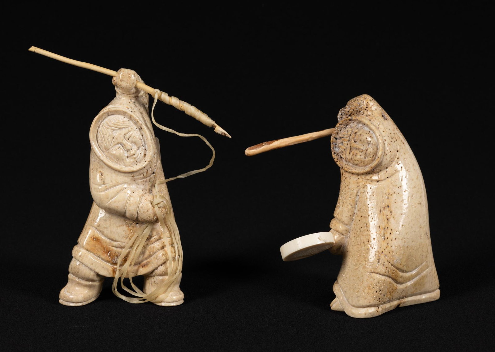 2 Carved Inuit Fossilized Bone Figures by Chivly Chupak: NOT ELIGIBLE FOR IN-HOUSE SHIPPING. Figures are 4-1/2" height not including attachments. Overall good condition.