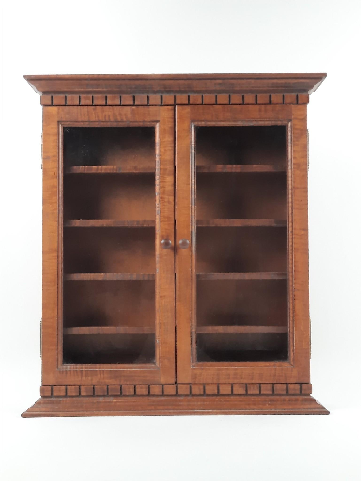 Tiger Maple Collector’s Cabinet Forest Lake Cabinetry Dauphin, PA: NOT ELIGIBLE FOR IN-HOUSE SHIPPING. Forest Lane Cabinetry Plaque on inside. 22" wide x 4-1/2" deep x 24-1/2" high. PROVENANCE: Sale of this item to benefit Historic Harrisburg Association.