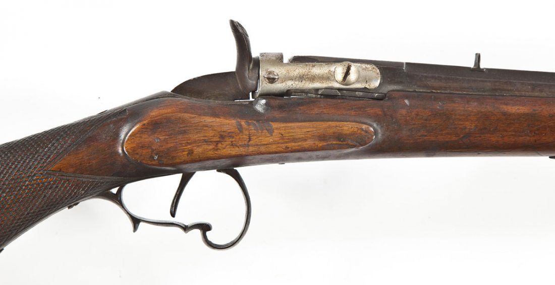 Unmarked Flobert Style Rifle - .22 Cal.: SERIAL #: None DESIGN: Hammer operated, breech loaded. 23-3/8" octagon barrel. MATERIAL/FINISH COMPOSITION: Blued steel. Checkered pistol grip stock. Unfinished breech plate. FEATURES: Blade front sig