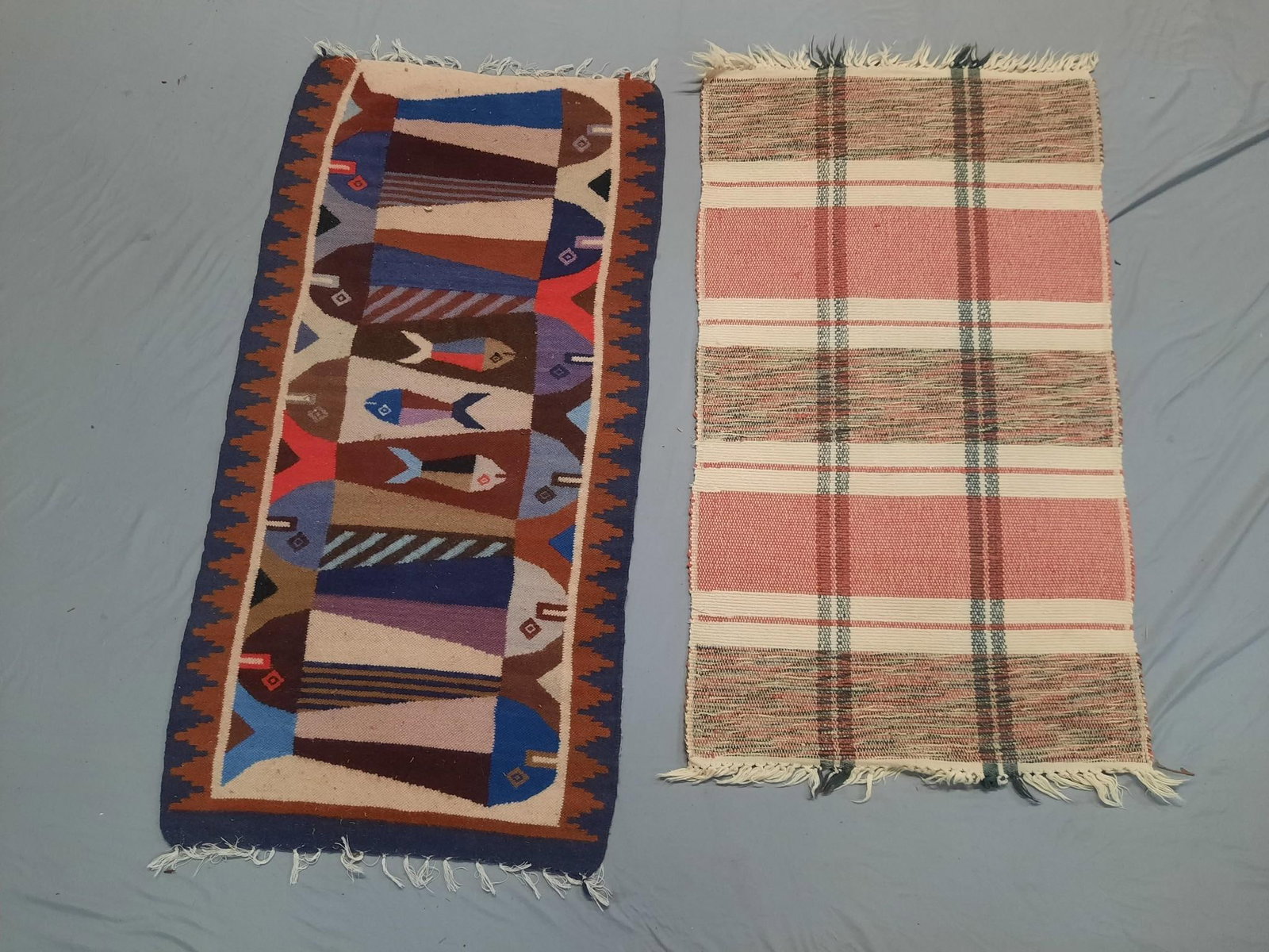 2 Scatter Rugs incl Fish Motif: Includes woven striped rug (possibly picnic blanket). Also includes South American Fish Weave Rug. Striped Rug 20" x 37". Fish Rug 19-3/4" x 38". Overall issues with fringe.