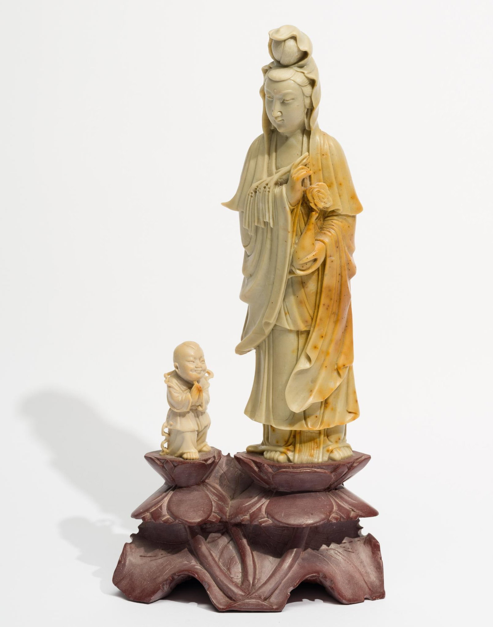 Soapstone Carved Figurine: Female carved figure with small male figure mounted on a soapstone pedestal. 7" wide x 13-5/8" high.