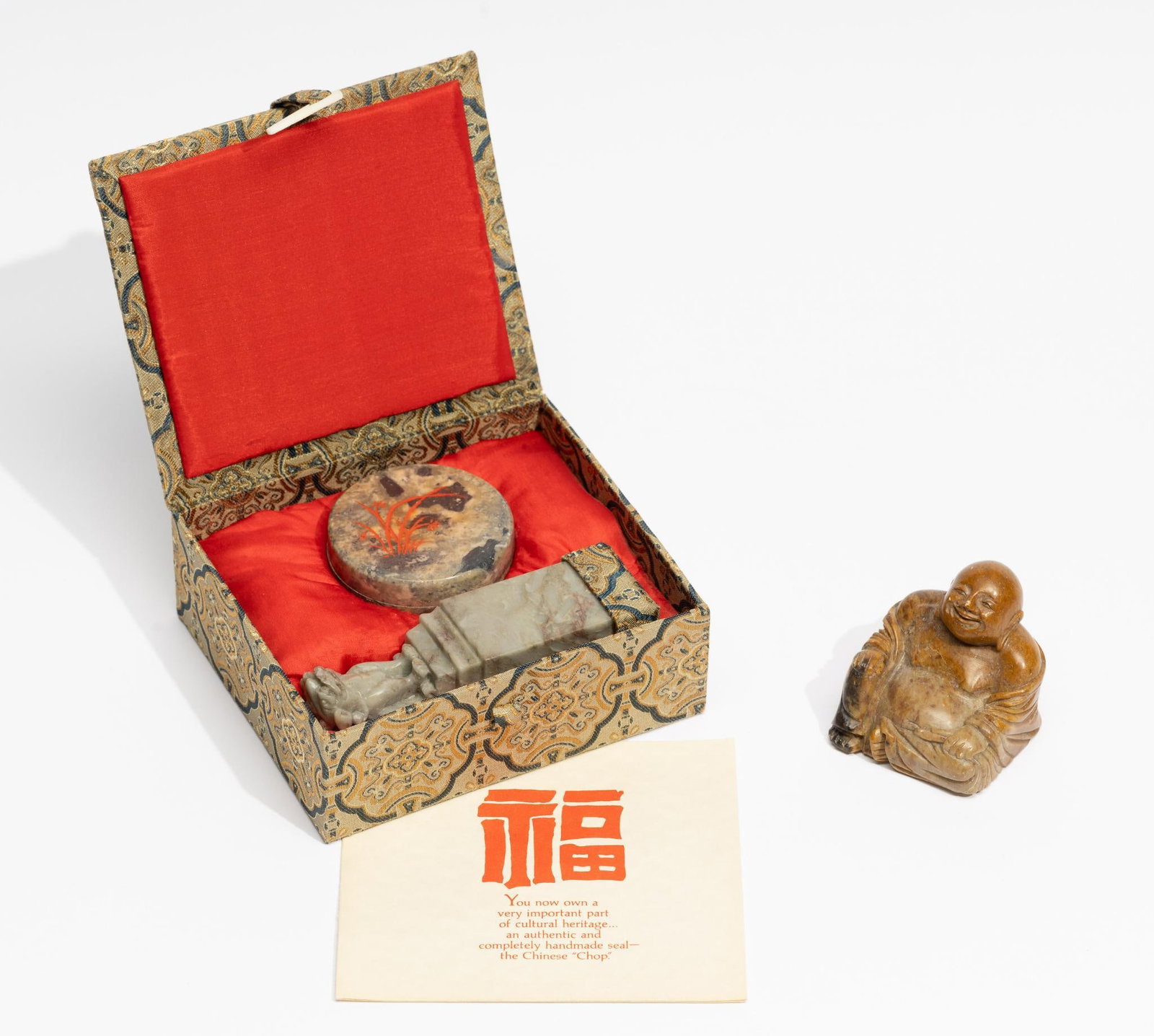 Soapstone Buddha & Soapstone Chop in OB: Soapstone carved smiling Buddha. Soapstone carved chop (seal) with soapstone ink pad. Chop with original user instructions in original box. Buddha measures 2" wide x 2" high. Chop box measures 5" wide