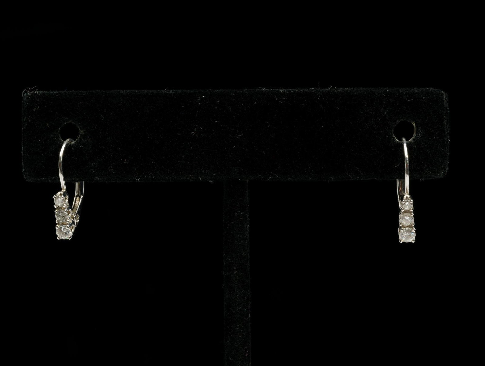 14K White Gold .32 CTW Diamond Earrings: Marked 14k white gold earrings each with three round diamonds, .03 to .08 carat. 1/2" high. 0.8 gram.