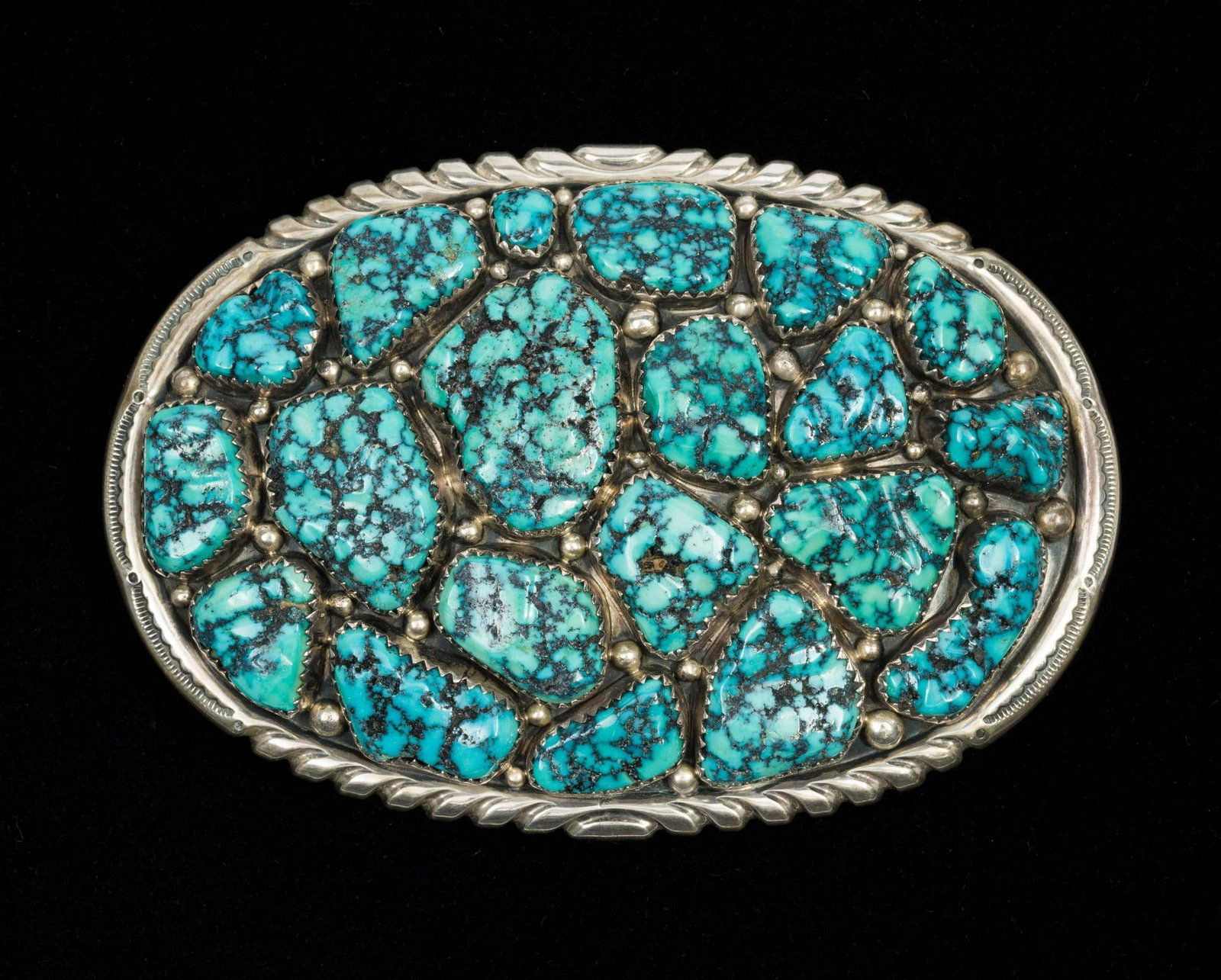 Wilford Nez Sterling Silver and Turquoise Belt Buckle: 3 1/2" X 2 3/8" oval belt buckle with turquoise stones by Wilford Nez, Navajo. Weight is 2.2 troy ounces.