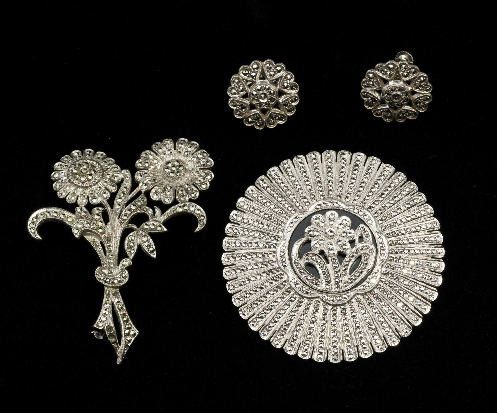 3 Pcs Antique Sterling Marcasite Jewelry: Includes pair of screw-back clip earrings, 2-1/2" high flower form brooch, and 2-1/4" wide circular brooch.